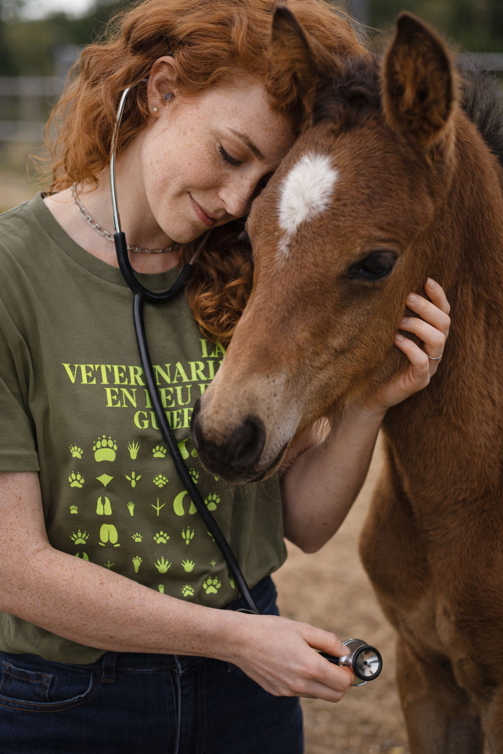 Veterinària amb samarreta de cotó orgànic Dogma BCN abraçant un poltre. Disseny animalista 'La veterinaria en peu de guerra' ideal per a professionals del sector eqüestre.